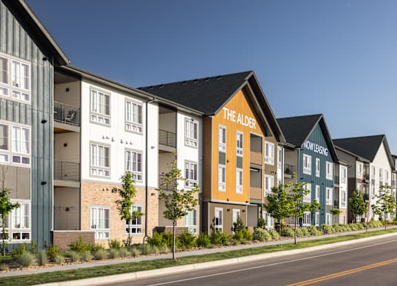 Apartment buildings are lined up along a street.