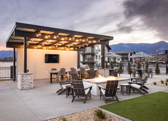 Outdoor entertainment kitchen with TV and firepit at The Allaso Peak, Colorado Springs, CO