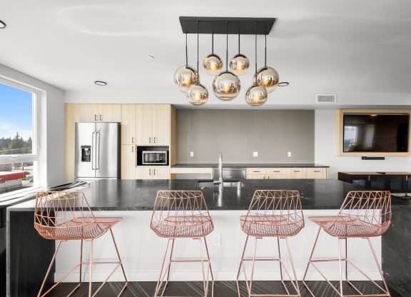 a kitchen with a large center island with a breakfast bar and copper bar stools at Ion Town Center, Washington