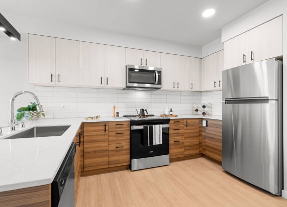 a kitchen with white countertops and wooden cabinets at Ion Town Center, Shoreline, WA