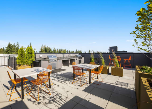 a patio with tables and chairs and a grill on a rooftop at Ion Town Center, Shoreline Washington