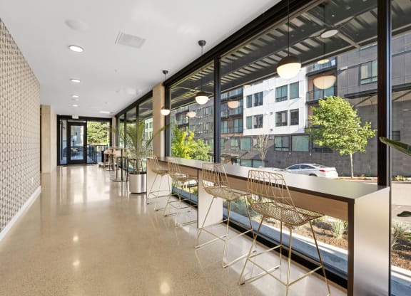a long corridor with a long counter and a row of chairs in front of a large window at Ion Town Center, Shoreline Washington