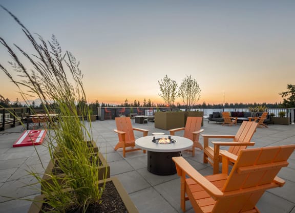 a patio with a firepit and chairs on a roof  at Ion Town Center, Shoreline Washington