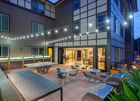 Courtyard patio with string lights and ping pong table at Six Oaks Apartments, Bothell, WA