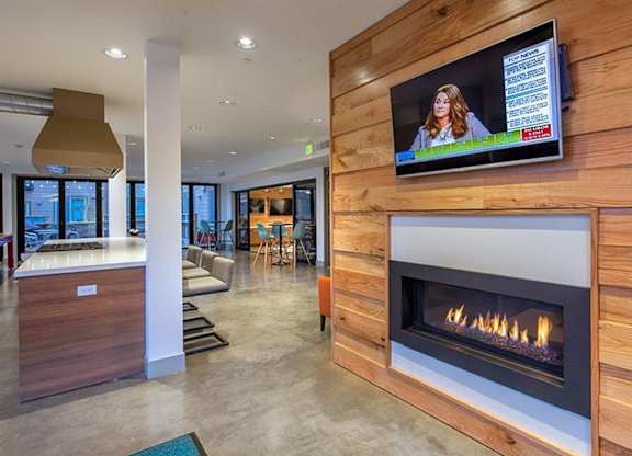 Clubhouse lounge with fireplace and flatscreen tv at Six Oaks Apartments, Bothell, 98011