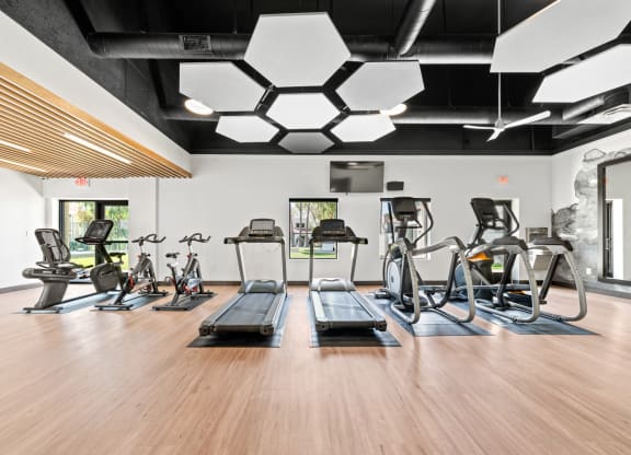 a spacious fitness center with treadmills and ellipticals