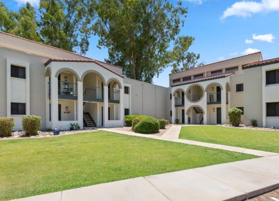 Residential building with a lawn and trees in front of it