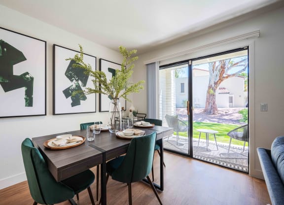 a dining room with a wooden table and green chairs