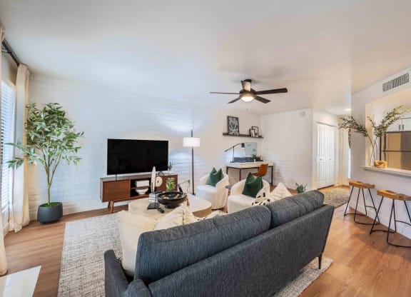 a living room with white walls and a ceiling fan