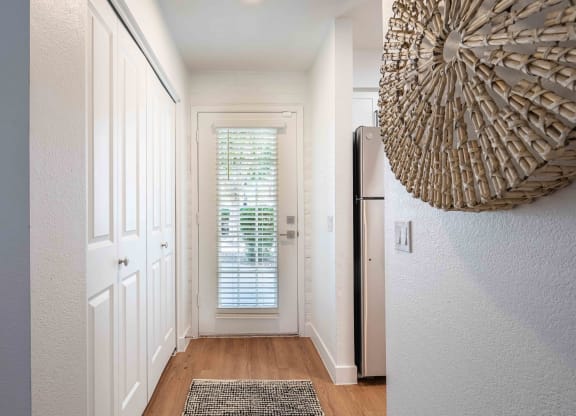 a hallway with white walls and wood floors