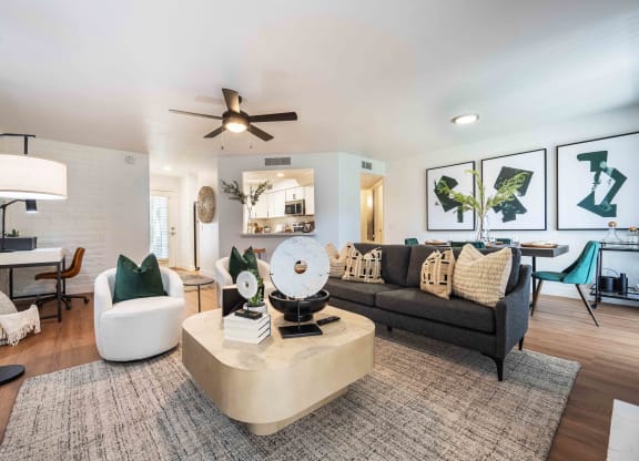 a living room filled with furniture and a ceiling fan