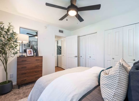 a bedroom with a bed and a ceiling fan