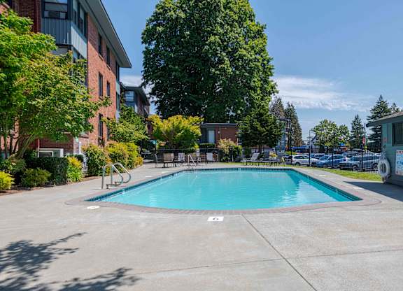 A swimming pool surrounded by trees and buildings.