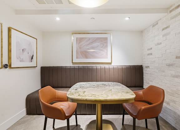 A dining room with a round table and four chairs.