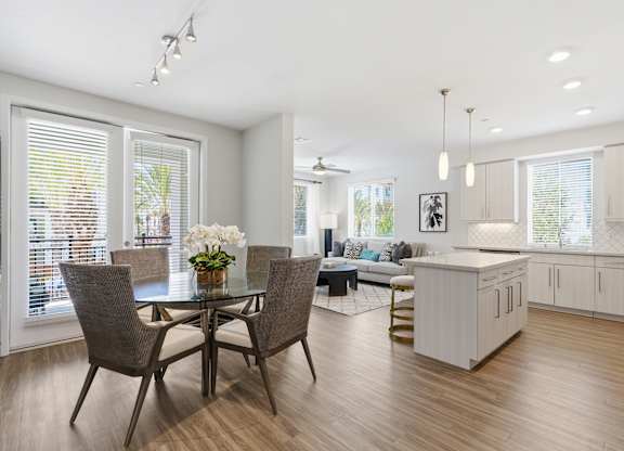 A modern dining room with a glass table and chairs.