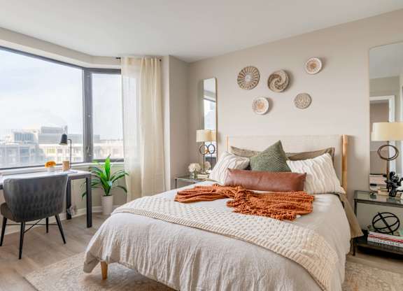 A bedroom with a large bed and a view of the city.