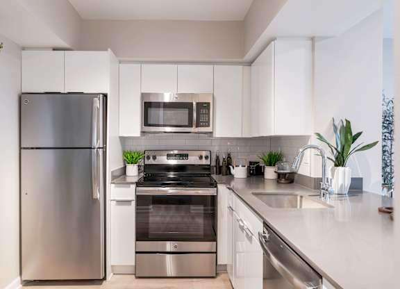 A modern kitchen with stainless steel appliances and white cabinets.