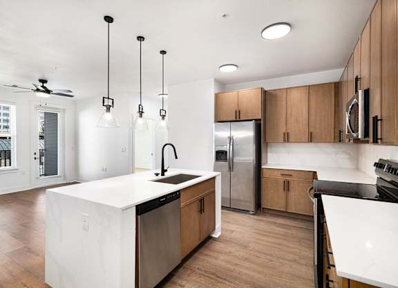 A modern kitchen with wooden cabinets and a white island.