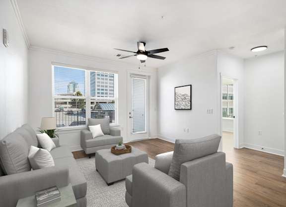 A living room with grey couches and a ceiling fan.