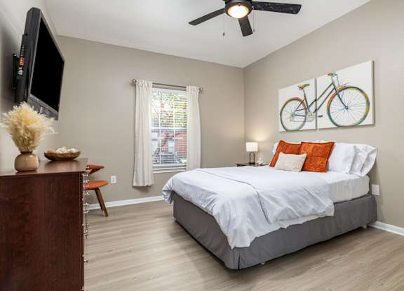 A bedroom with a large bed and a television on the wall at Clear Creek Meadows Apartments, Copperas Cove, 76522