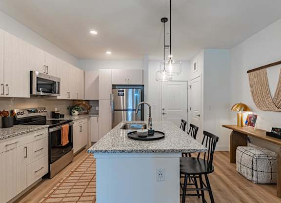 A kitchen with a granite countertop and a dining area with a bench.