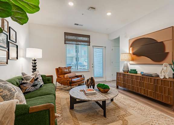 A furnished living room with a sofa and chair at Firestone Junction apartments for rent in Northern Colorado.