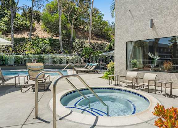 A hot tub with lounge chairs.