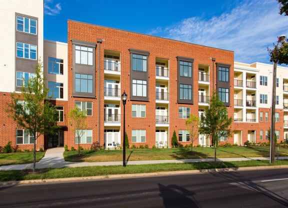 a red brick apartment building on the side of a street
