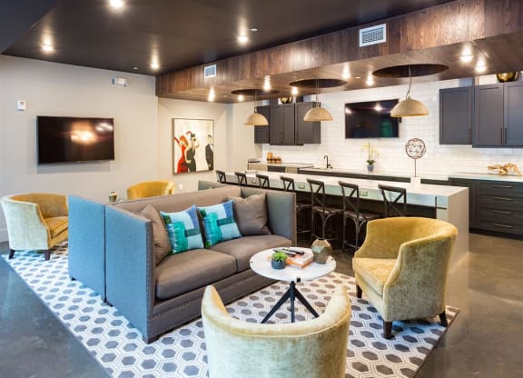 a living room and kitchen with a couch and chairs