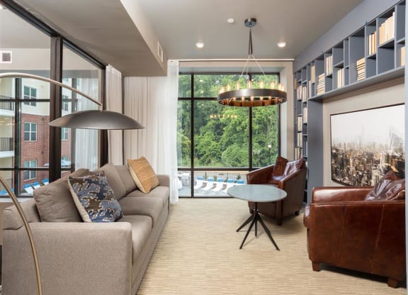 a living room with a couch and a chair and a large window