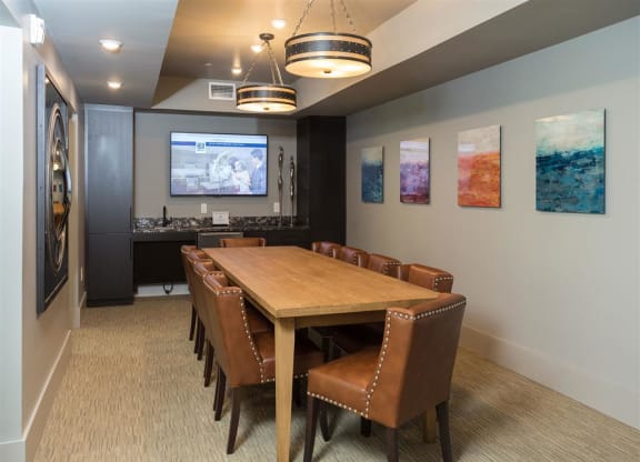 a conference room with a table and chairs and a tv