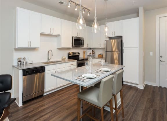 a kitchen with stainless steel appliances and a marble counter top