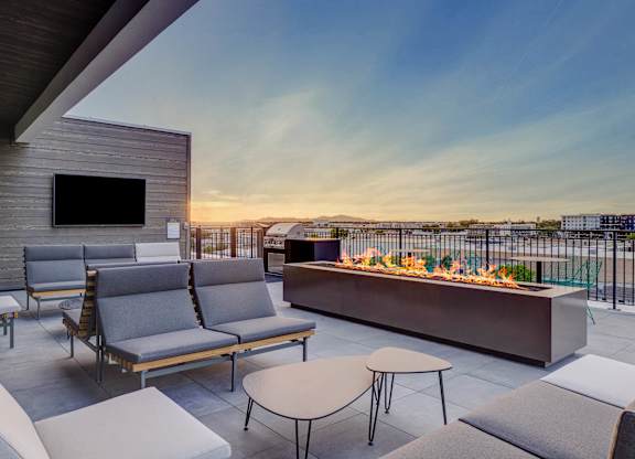 A patio with a fire pit and seating area.