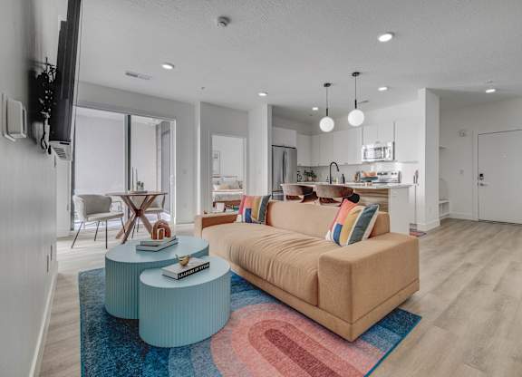 A living room with a couch, a coffee table, and a television.