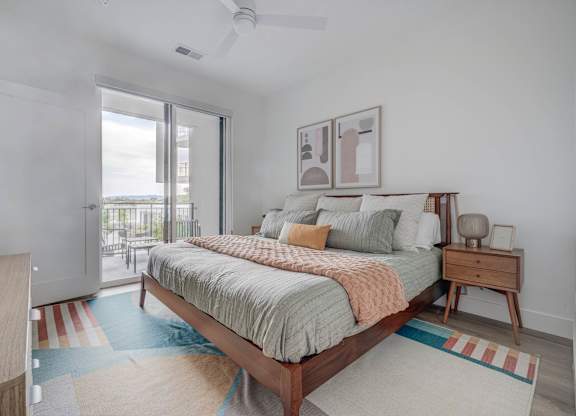 A bedroom with a bed, nightstand, and a ceiling fan.
