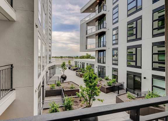 A balcony with a view of a building and a tree.