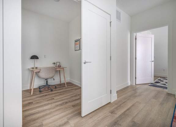 A room with a desk and chair in it.