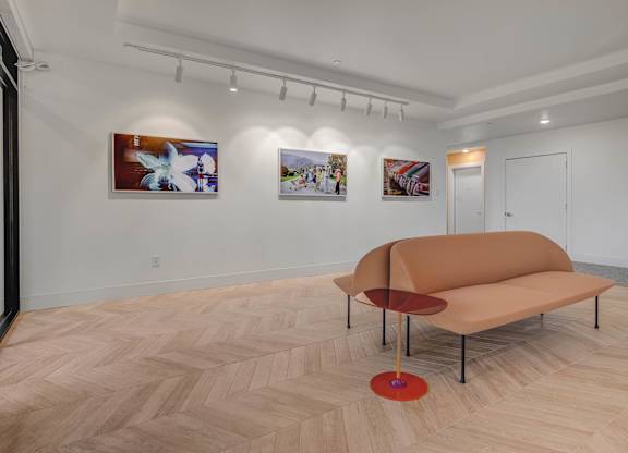 A room with a tan couch and a red table.