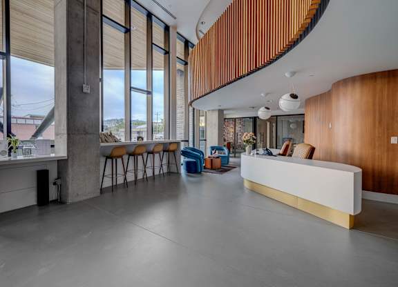 A reception area with a white counter and orange chairs.