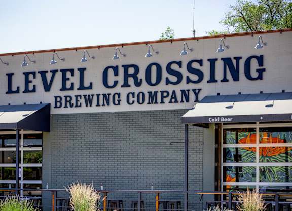 A beer company called Level Crossing has a building with a sign on it.