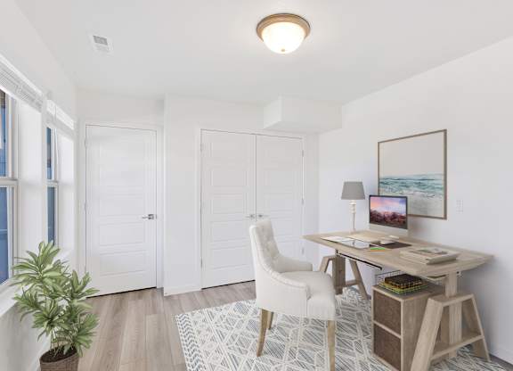 a home office with white walls and white doors and a desk with a white chair
