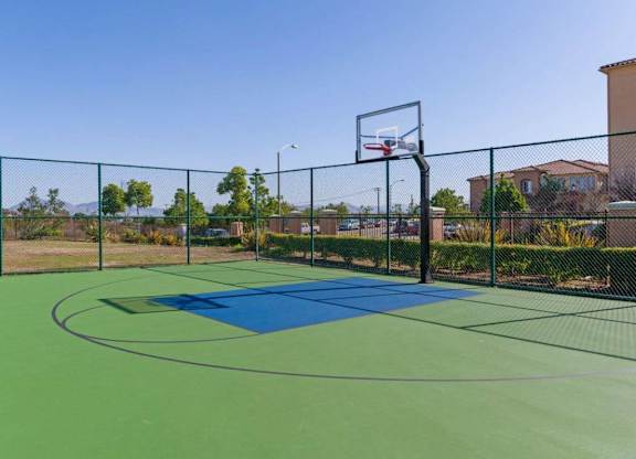 A basketball court with a blue mat and a basketball hoop.