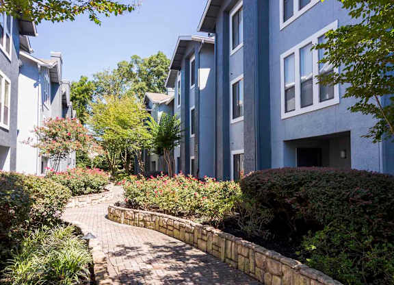 a brick path leading to an apartment building