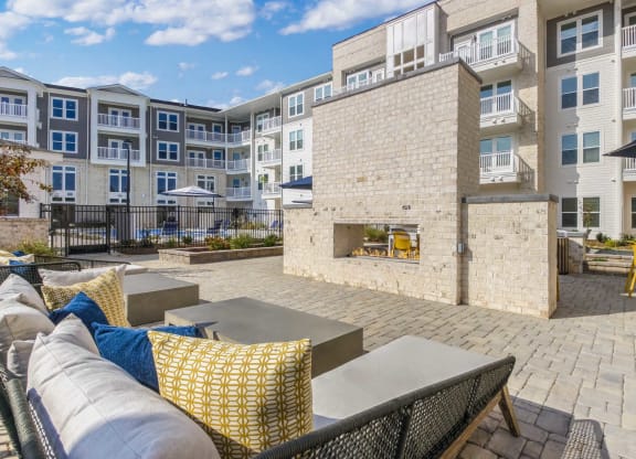an outdoor patio with a fireplace and tables and chairs