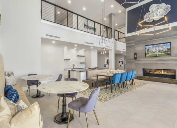 a lobby with tables and chairs and a fireplace