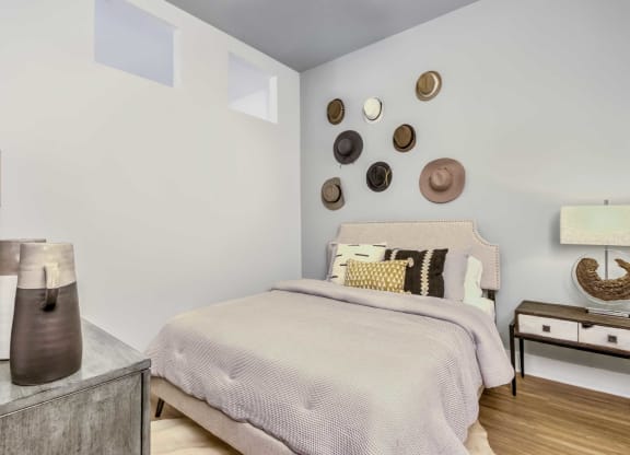 a bedroom with a bed and several hats on the wall