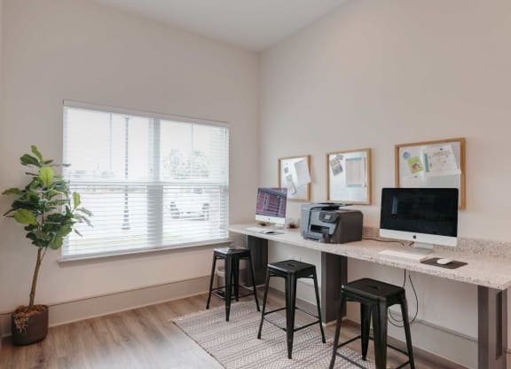 a home office with a computer and a desk with stools