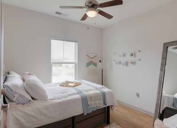 a bedroom with a bed and a ceiling fan