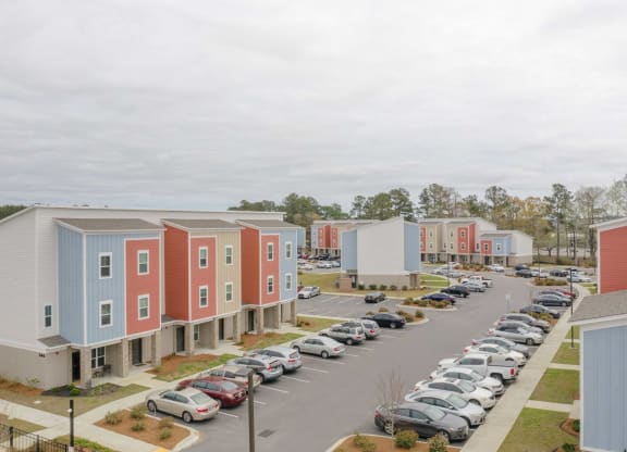 a row of colorful houses next to a parking lot