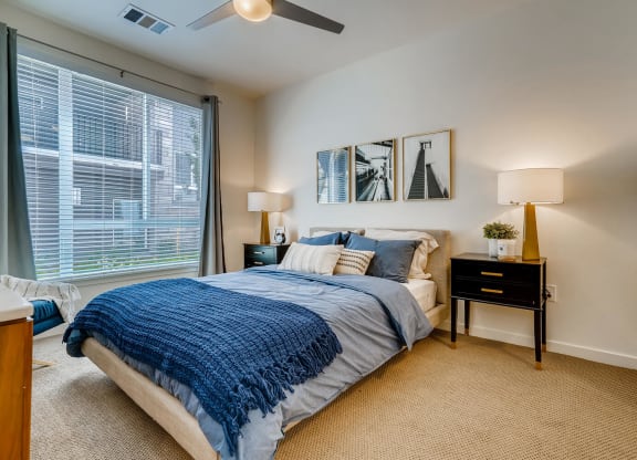 a bedroom with a large window and a bed